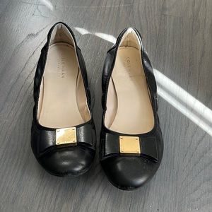 Coke Hann black flat shoe with gold bow